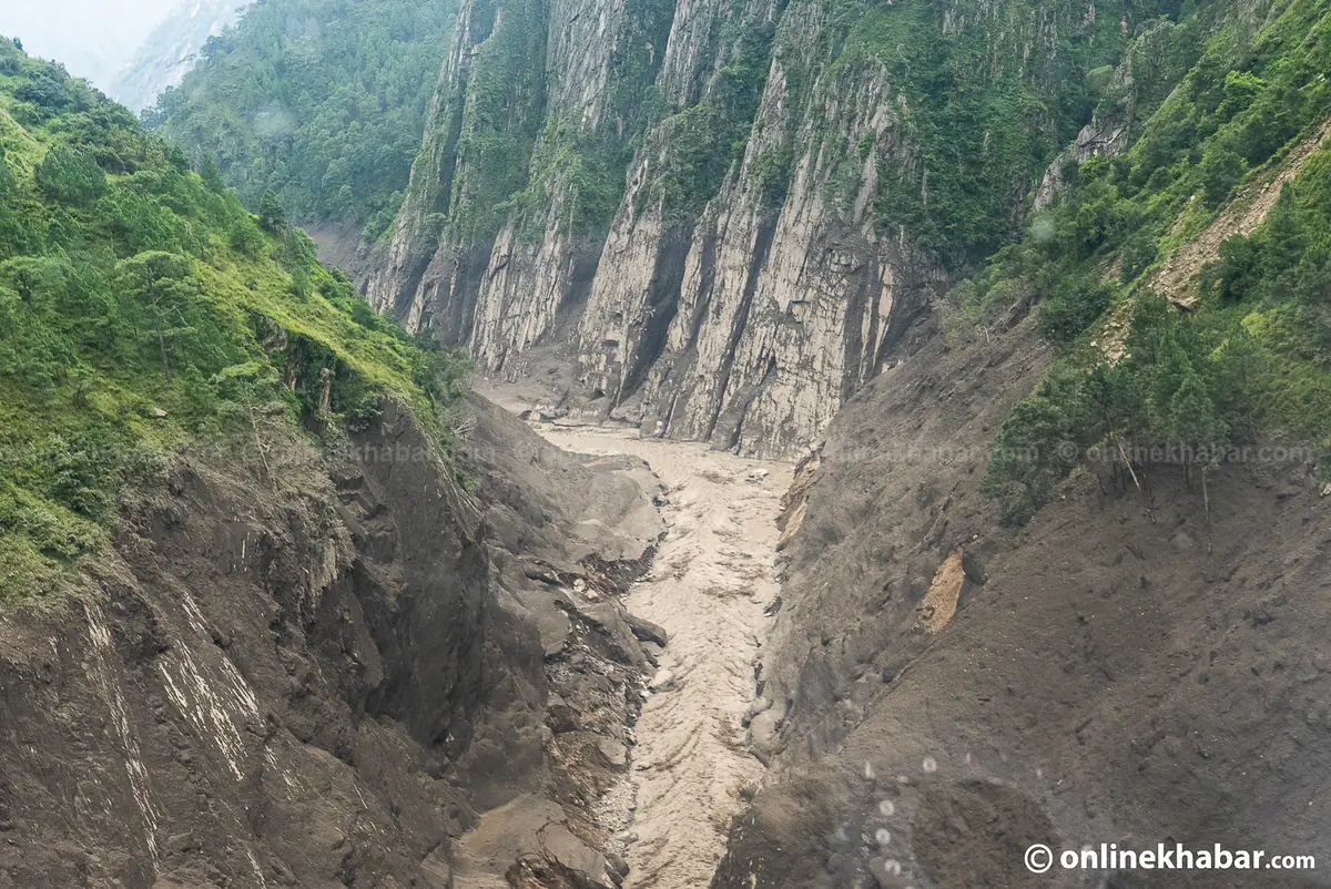 A steep narrow gorge with near-vertical rock walls scoured pale by the passing flood