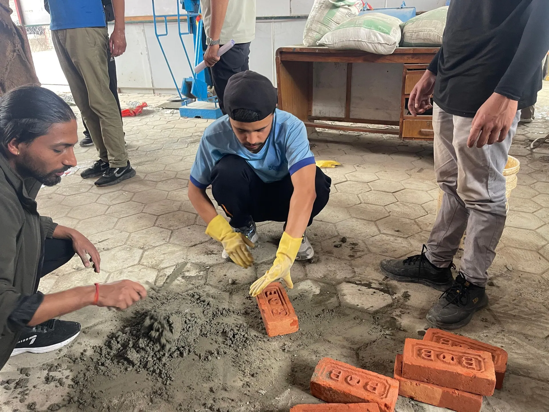 An ICE student bedding a brick into fresh mortar during a concrete and materials practical