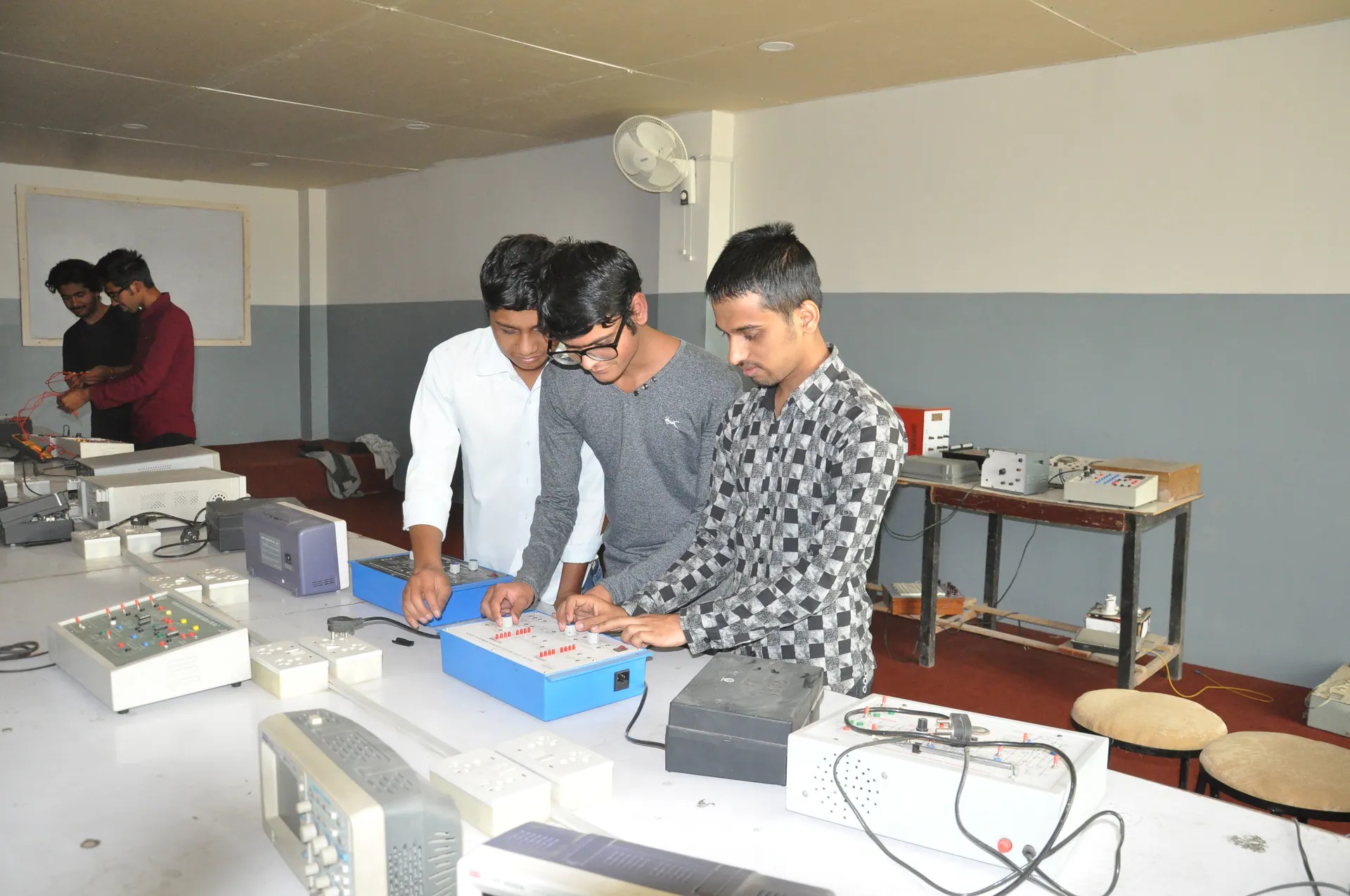 Electronics students testing a circuit with their instructor