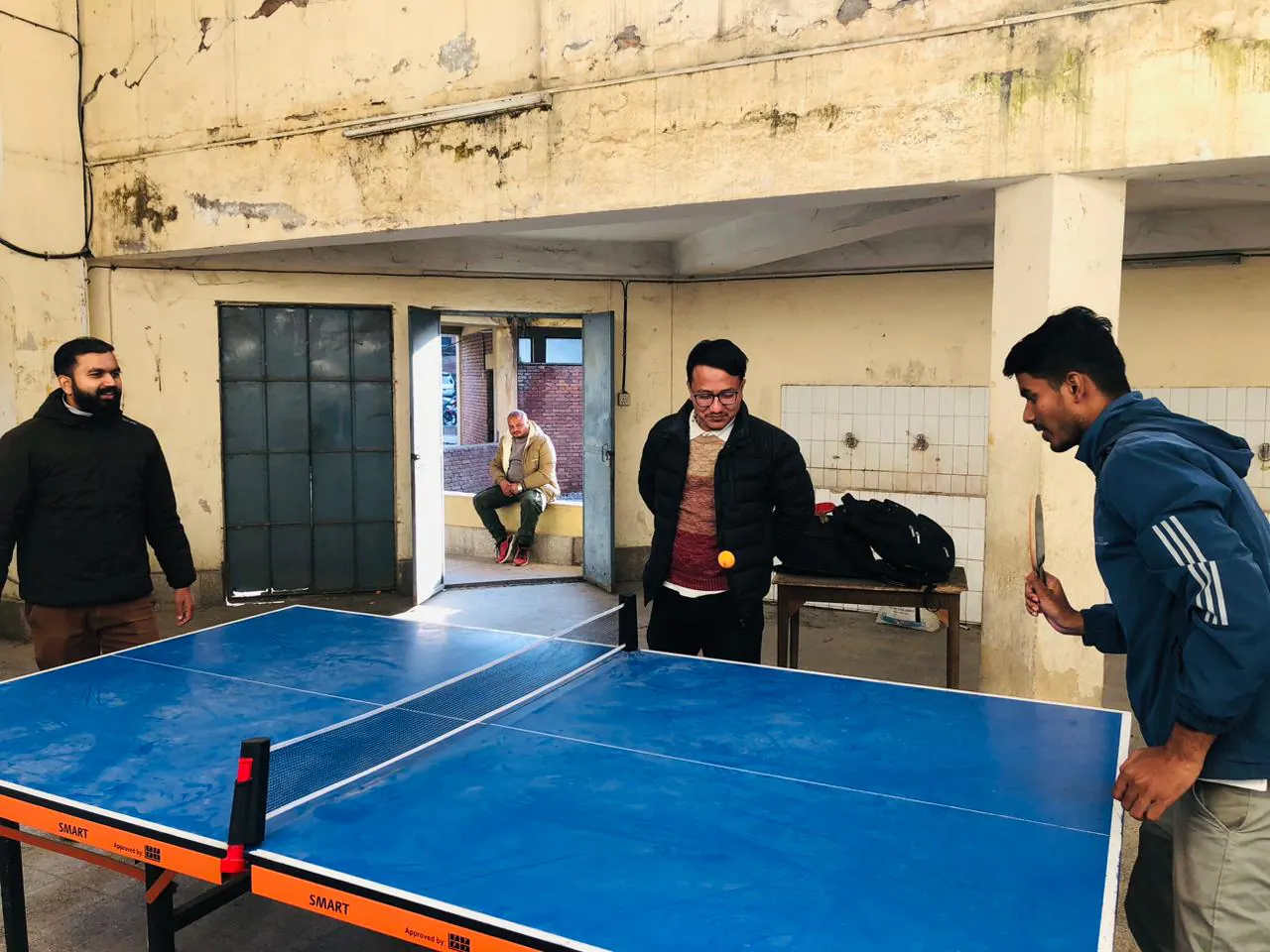 Students playing table tennis in an indoor recreation space