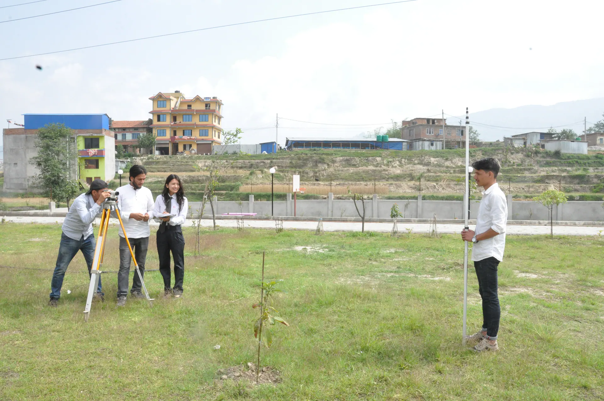 ICE students practising with a level and staff on the campus ground